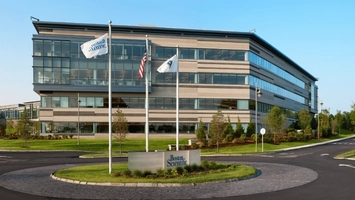 Boston Scientific corporate campus exterior showing glass-fronted building and flagpoles at the entrance
